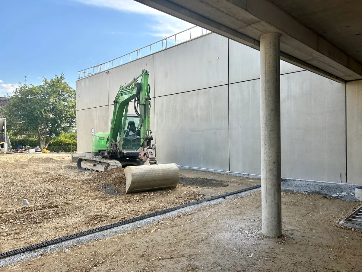 Man sieht einen Bagger im Aussenbereich.